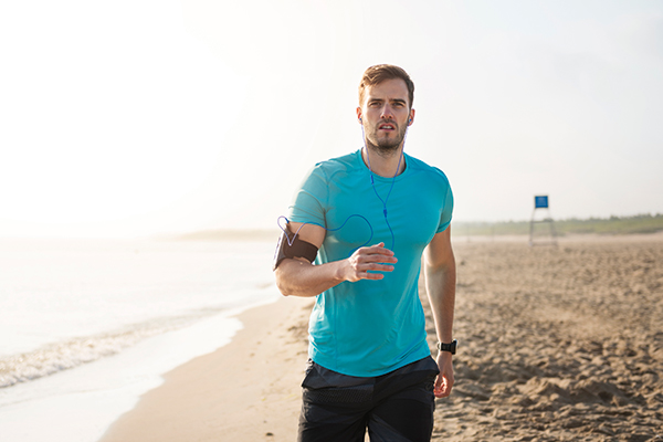 Bild Mann mit blauem t-Shirt joggt am Strand